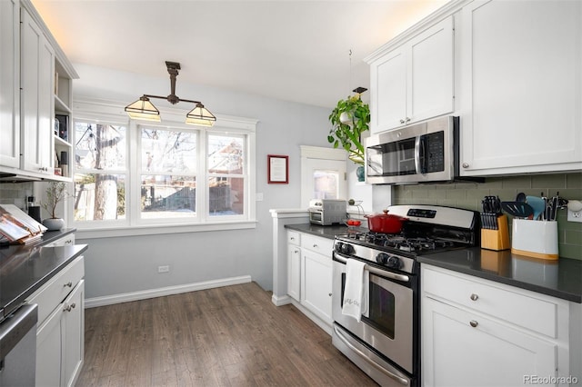 kitchen with decorative light fixtures, plenty of natural light, white cabinets, and appliances with stainless steel finishes