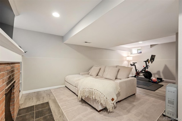 bedroom featuring hardwood / wood-style flooring and a fireplace