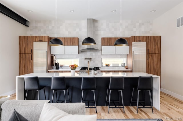 619 S High St, Denver, CO 80209 - kitchen featuring light countertops, built in fridge, baseboards, and a large island