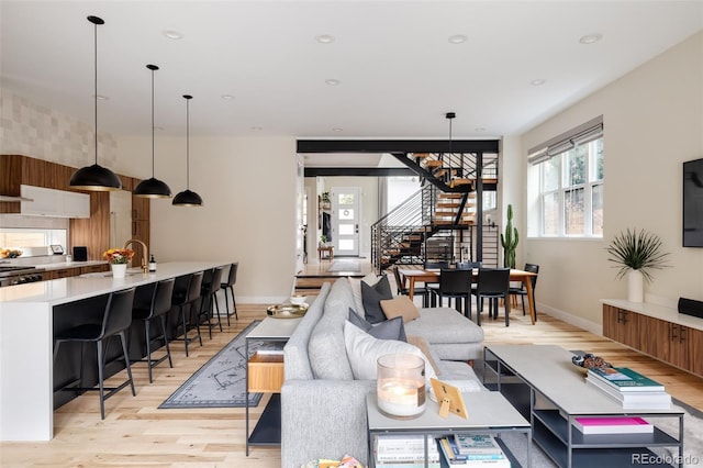 619 S High St, Denver, CO 80209 - living room with stairs, light wood-style floors, and baseboards