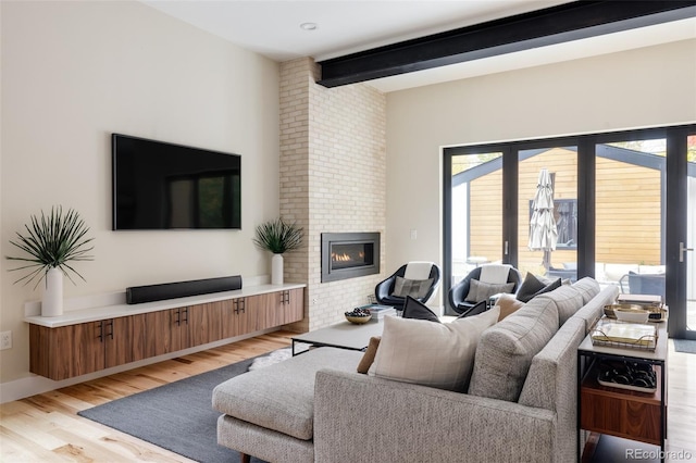 619 S High St, Denver, CO 80209 - living room featuring beamed ceiling, light wood-style floors, a fireplace, and baseboards