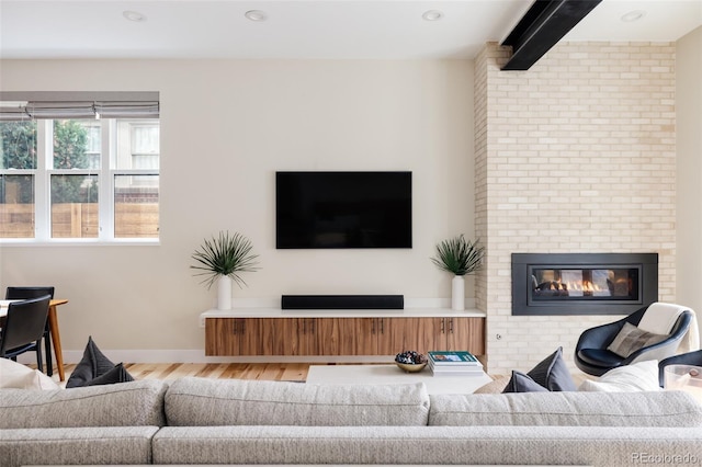 619 S High St, Denver, CO 80209 - living area featuring wood finished floors, a brick fireplace, and baseboards