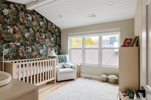 619 S High St, Denver, CO 80209 - bedroom with wallpapered walls, wood finished floors, and a nursery area