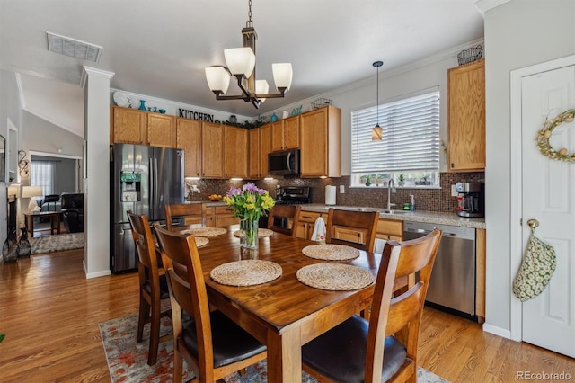 2670 E 136th Pl, Thornton, CO 80602 - dining space featuring light wood-type flooring, crown molding, and a chandelier