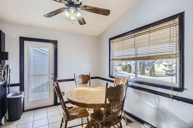 tiled dining space with vaulted ceiling and ceiling fan