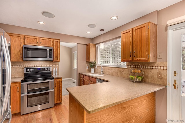8588 S Woody Way, Highlands Ranch, CO 80126 - kitchen with stainless steel appliances, a peninsula, backsplash, light stone counters, and recessed lighting