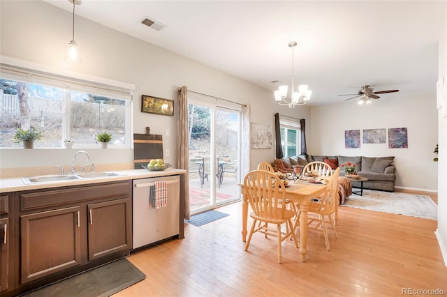 dining area with ceiling fan with notable chandelier, light wood-type flooring, and visible vents