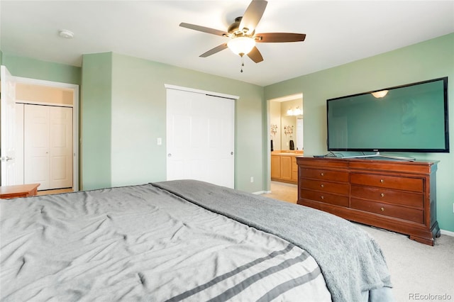 bedroom with a ceiling fan, light colored carpet, connected bathroom, and baseboards