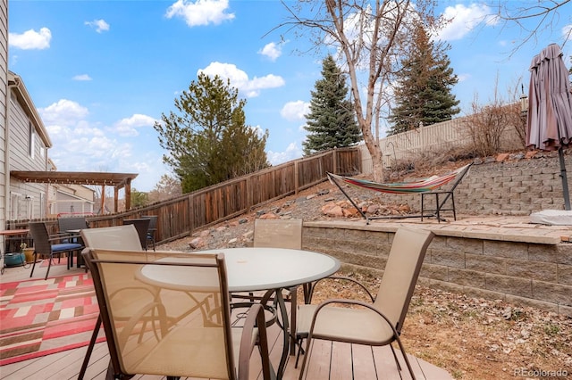 view of patio with outdoor dining area, a fenced backyard, and a wooden deck