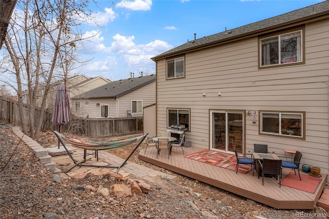 back of house featuring a deck, outdoor dining space, and fence