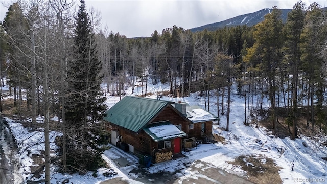 9061 N Rex Ln, Conifer, CO 80433 - snowy aerial view featuring a wooded view and a mountain view