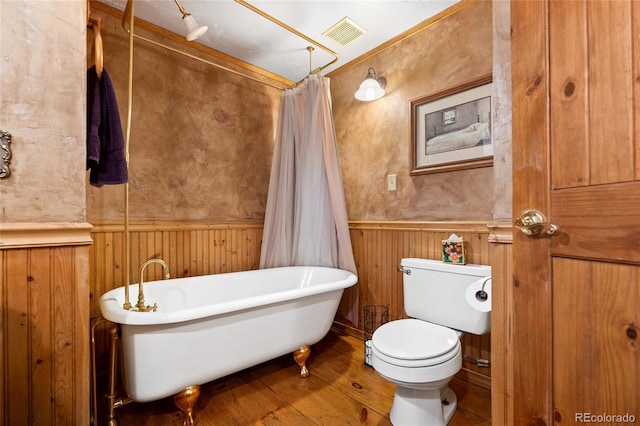 9061 N Rex Ln, Conifer, CO 80433 - bathroom featuring wainscoting, a freestanding tub, wood finished floors, and toilet