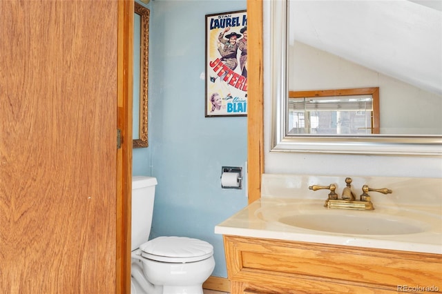 9061 N Rex Ln, Conifer, CO 80433 - half bathroom featuring toilet, lofted ceiling, and vanity