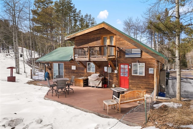 9061 N Rex Ln, Conifer, CO 80433 - snow covered property with a deck, metal roof, and outdoor dining area