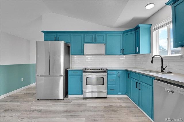 3470 W Walsh Pl, Denver, CO 80219 - kitchen with stainless steel appliances, vaulted ceiling, blue cabinetry, light countertops, and decorative backsplash
