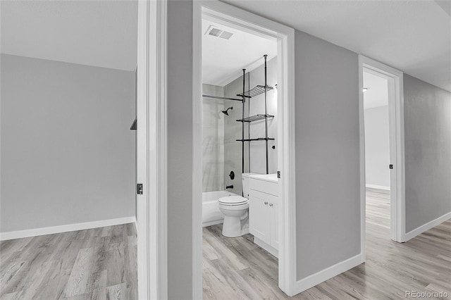 3470 W Walsh Pl, Denver, CO 80219 - bathroom featuring wood finished floors, vanity, and shower / tub combination