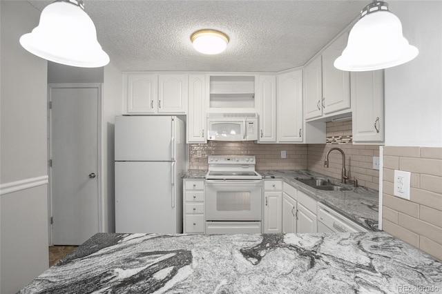 kitchen with white cabinetry, light stone counters, and white appliances