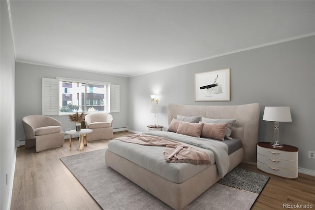 bedroom with a baseboard heating unit, ornamental molding, and light wood-type flooring