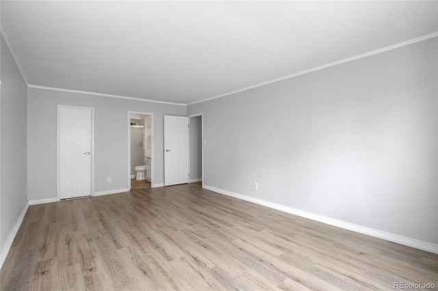 unfurnished bedroom featuring ensuite bathroom, crown molding, and light hardwood / wood-style floors