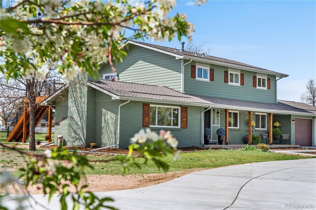traditional-style home with an attached garage, covered porch, brick siding, and roof with shingles
