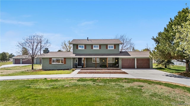 traditional home with covered porch, a garage, driveway, and a chimney