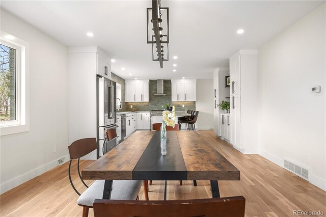 dining space featuring baseboards, recessed lighting, and light wood-style flooring