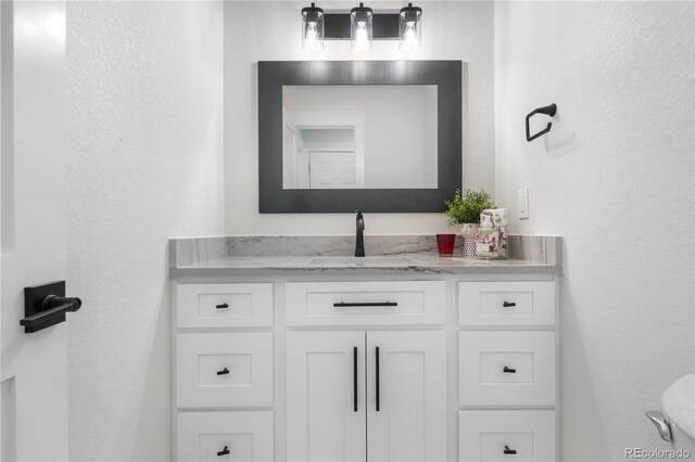 bathroom featuring vanity and a textured wall