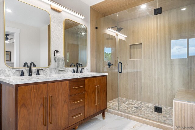 bathroom featuring a stall shower, marble look tiles, and double vanity