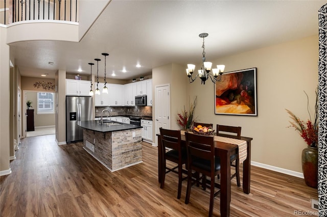 dining space featuring an inviting chandelier, sink, and dark hardwood / wood-style floors