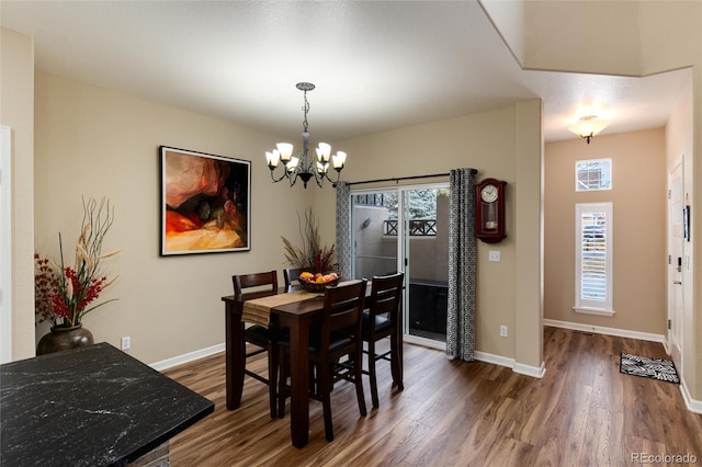 dining room with dark wood-type flooring and a chandelier