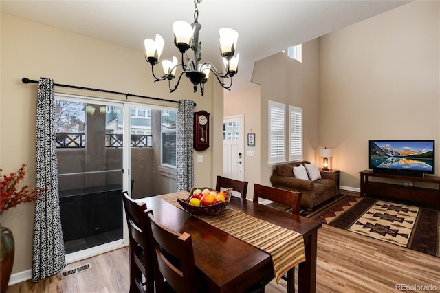 dining area featuring hardwood / wood-style flooring and a chandelier