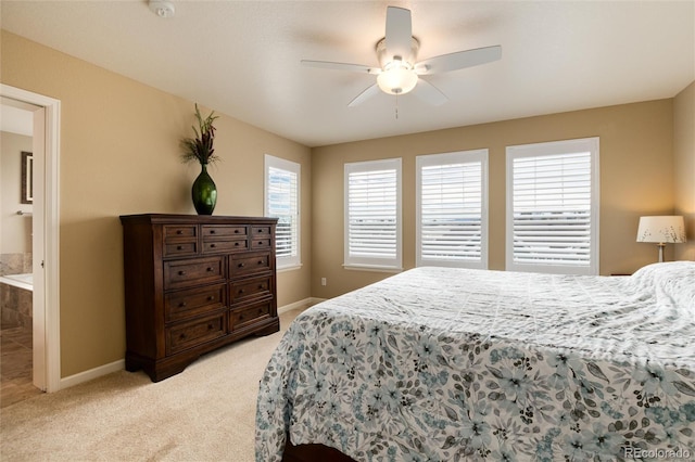 bedroom featuring light carpet, connected bathroom, and ceiling fan