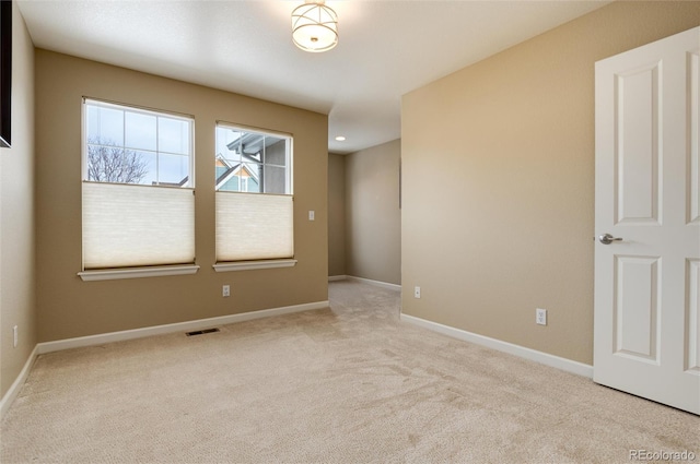 spare room featuring light colored carpet