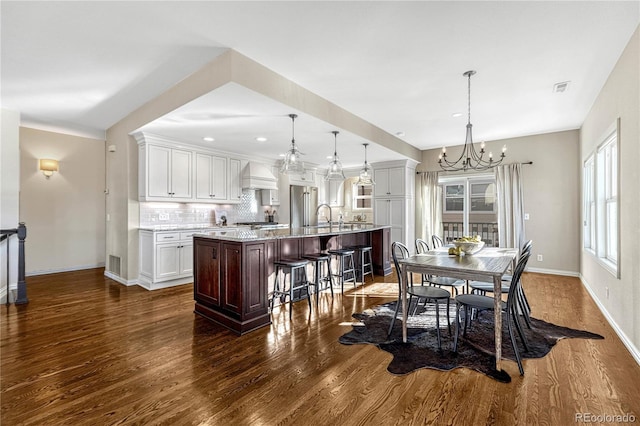 dining area with dark hardwood / wood-style floors, sink, and a chandelier