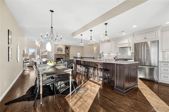 dining space with dark hardwood / wood-style flooring, a notable chandelier, and sink