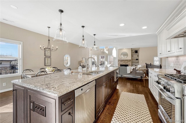 kitchen featuring white cabinets, decorative light fixtures, sink, and appliances with stainless steel finishes