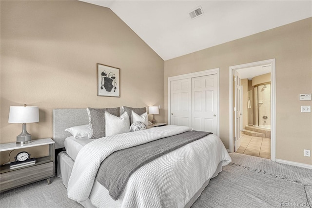 bedroom with ensuite bathroom, lofted ceiling, and a closet