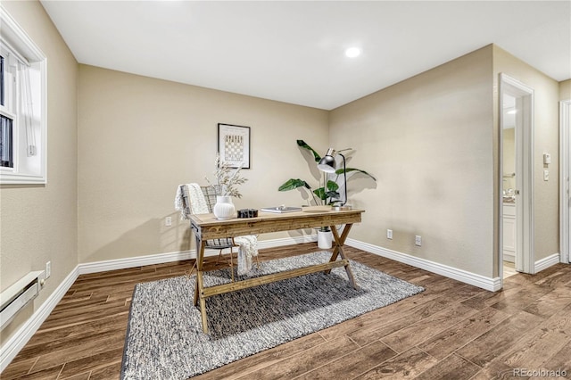 office space featuring wood-type flooring and a baseboard heating unit