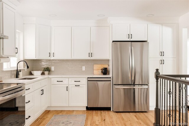 2263 Yellowstone St, Golden, CO 80401 - kitchen with appliances with stainless steel finishes, light wood-style floors, and white cabinets