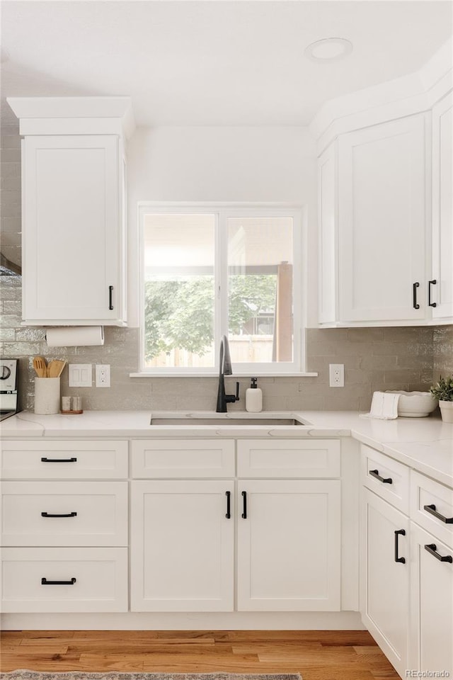 2263 Yellowstone St, Golden, CO 80401 - kitchen with backsplash, white cabinetry, light countertops, and light wood-style floors