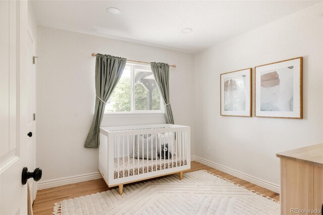 2263 Yellowstone St, Golden, CO 80401 - bedroom with light wood finished floors and a nursery area