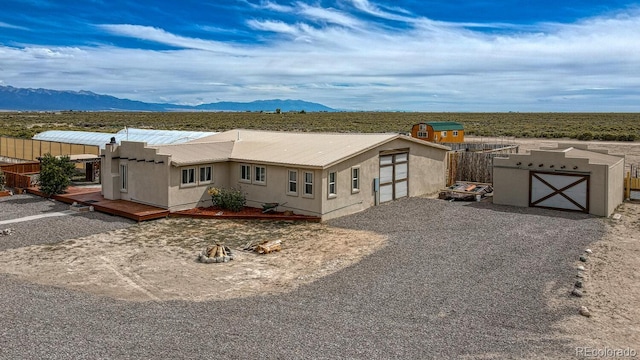 56506 County Road Aa, Moffat, CO 81143 - view of front facade featuring stucco siding, a deck with mountain view, and metal roof