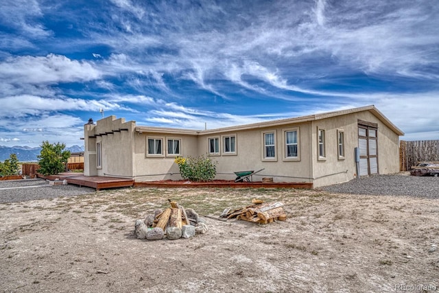 56506 County Road Aa, Moffat, CO 81143 - rear view of house with an outdoor fire pit, a deck, and stucco siding