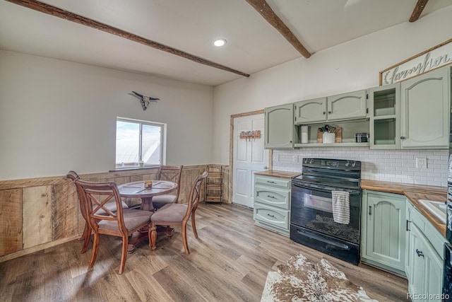 56506 County Road Aa, Moffat, CO 81143 - kitchen with green cabinets, black range with electric stovetop, beamed ceiling, a wainscoted wall, and light wood-style flooring