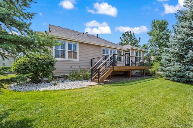 rear view of property featuring a yard and a wooden deck