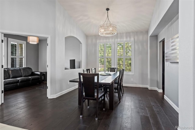 dining space with dark wood-type flooring and a chandelier