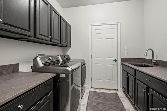 laundry area featuring washer and dryer, cabinets, and sink