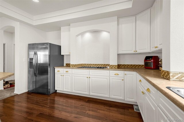 20109 Randolph Pl, Denver, CO 80249 - kitchen featuring stainless steel refrigerator with ice dispenser, arched walkways, white cabinetry, dark wood-type flooring, and black electric stovetop