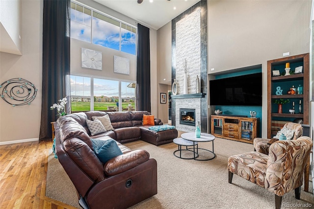 2349 Hickory Pl, Erie, CO 80516 - living room featuring wood finished floors, baseboards, a high ceiling, and a fireplace