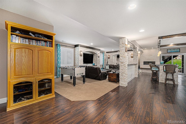 2349 Hickory Pl, Erie, CO 80516 - living room featuring decorative columns, baseboards, dark wood-type flooring, recessed lighting, and a large fireplace